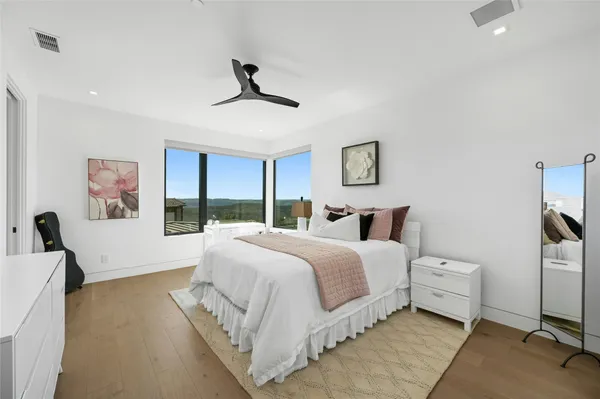 a spacious bedroom with a bed and a large window