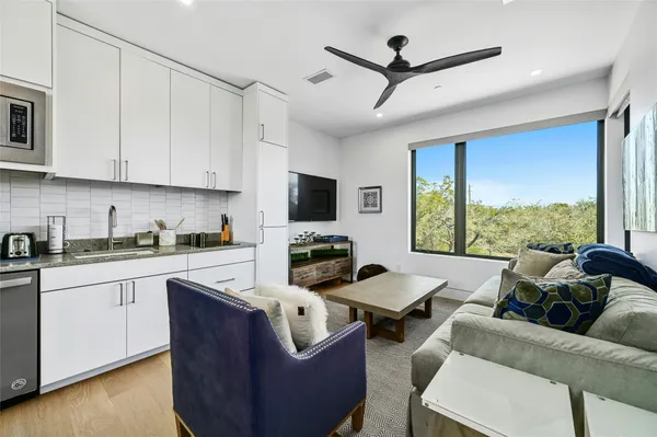 a living room with furniture a flat screen tv and a window
