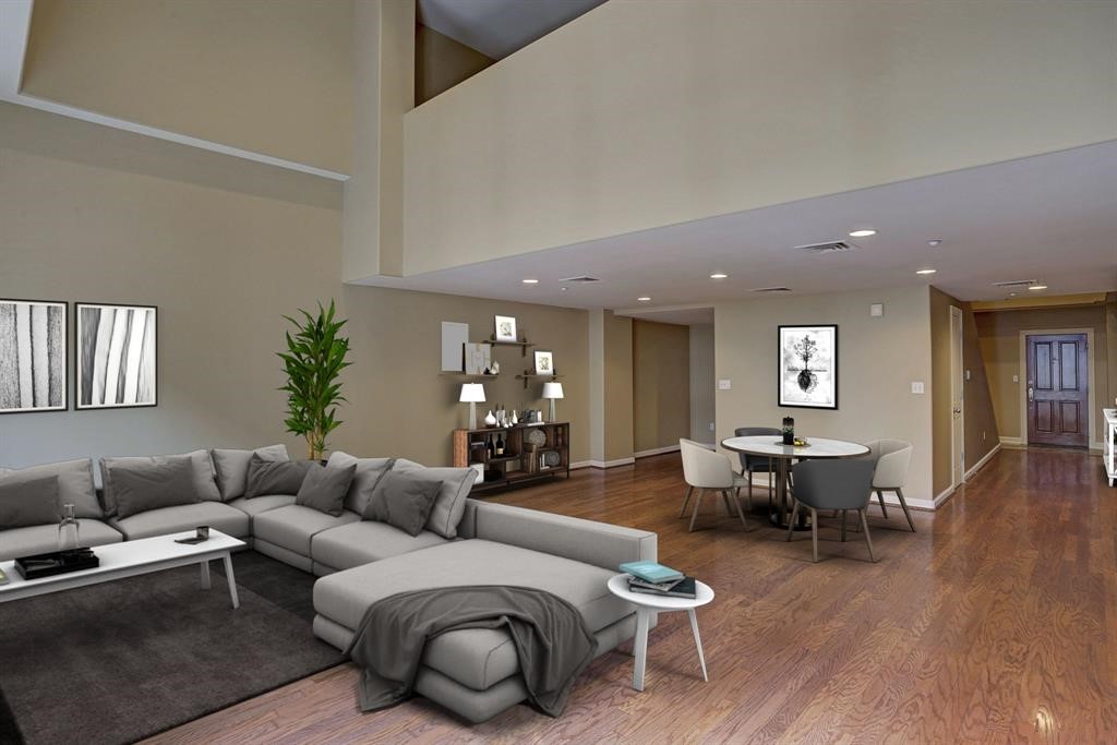 a living room with furniture a wooden floor and potted plant
