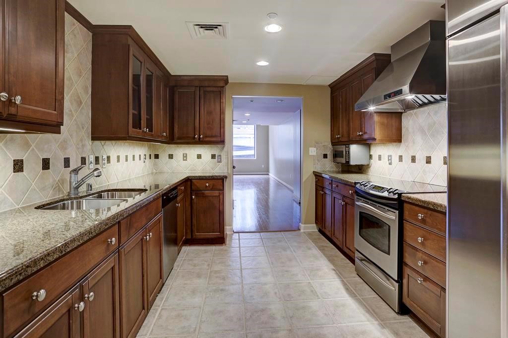 914 Main Street, Unit 1107 Houston, TX 77002 - Photo 2 of 14 a kitchen with stainless steel appliances granite countertop a stove sink and cabinets