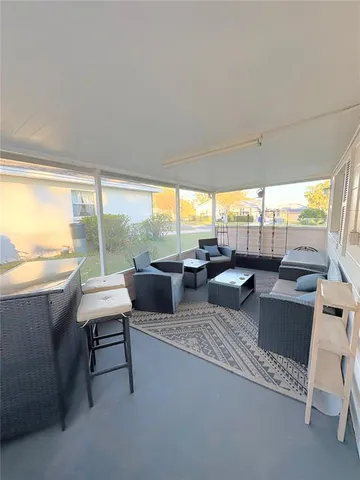 a living room with patio furniture and a floor to ceiling window