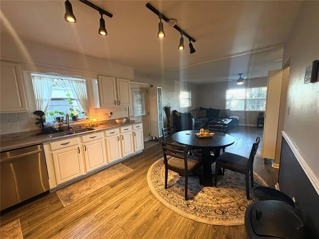 a kitchen with a dining table chairs and sink