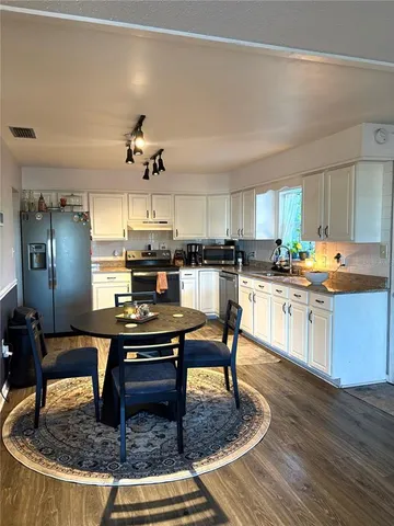 a kitchen with kitchen island granite countertop a stove a sink and a refrigerator