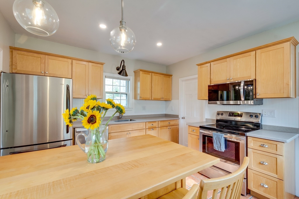 10 Eaton Street Reading, MA 01867 - Photo 9 of 15 a kitchen with stainless steel appliances granite countertop a sink and a refrigerator