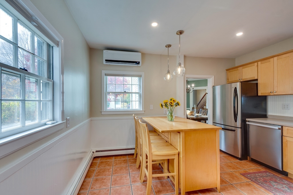 10 Eaton Street Reading, MA 01867 - Photo 10 of 15 a kitchen with kitchen island a large window appliances and cabinets