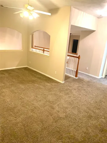 a view of a hallway with wooden floor and stairs