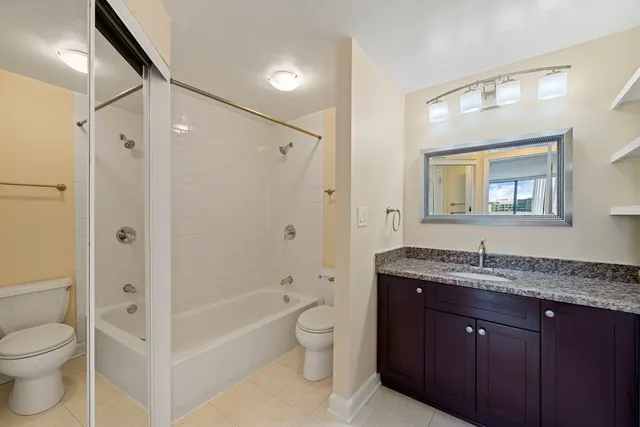a bathroom with a granite countertop sink toilet and shower