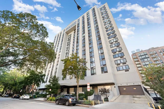 a front view of a multi story building with a yard