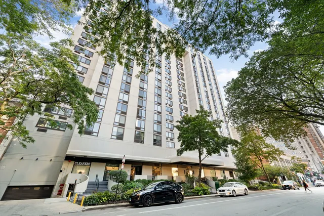 a view of a building and car parked on the side of road