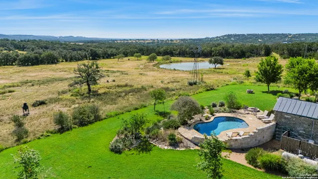 an aerial view of residential houses with outdoor space and lake view