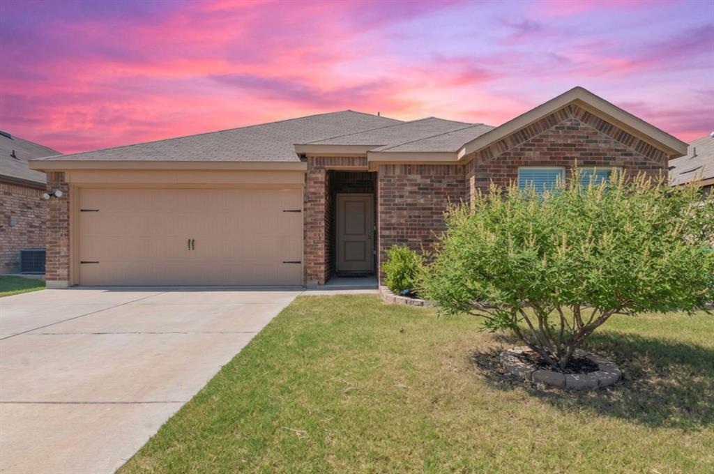 409 Wilson Way Denton, TX 76207 - Photo 32 of 33 Brick exterior featuring a two-car garage, concrete driveway, and mature landscaping
