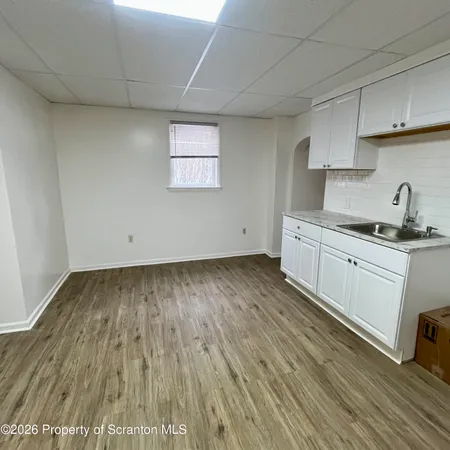 a kitchen with wooden floors and white walls