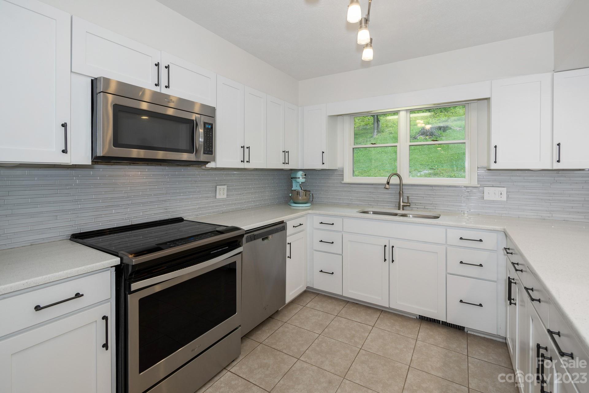 298 Camp Rock Road, Unit 14 Boone, NC 28607 - Photo 17 of 45 a kitchen with granite countertop white cabinets white stainless steel appliances and a sink