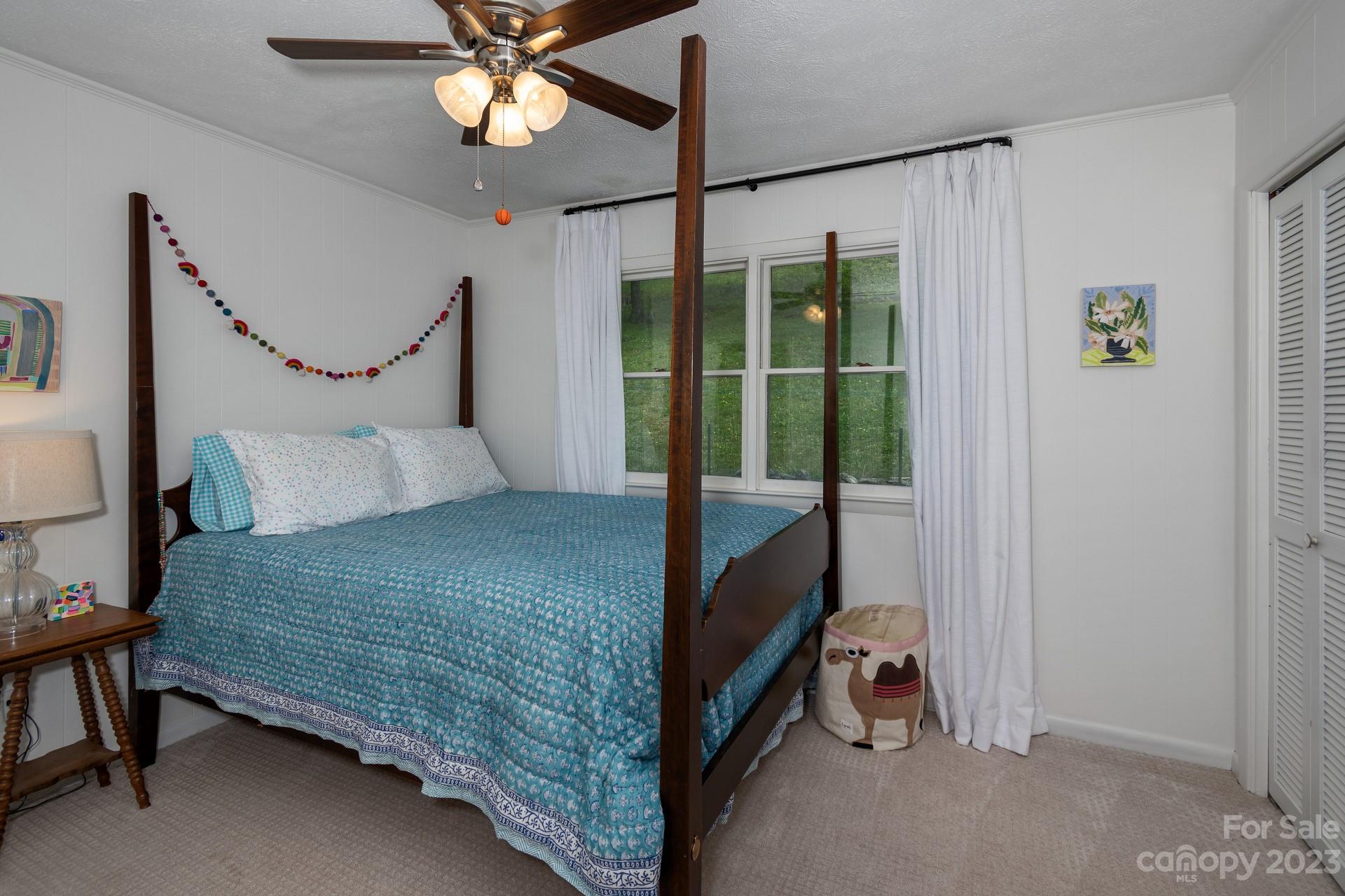 298 Camp Rock Road, Unit 14 Boone, NC 28607 - Photo 29 of 45 a bedroom with a bed and a chandelier