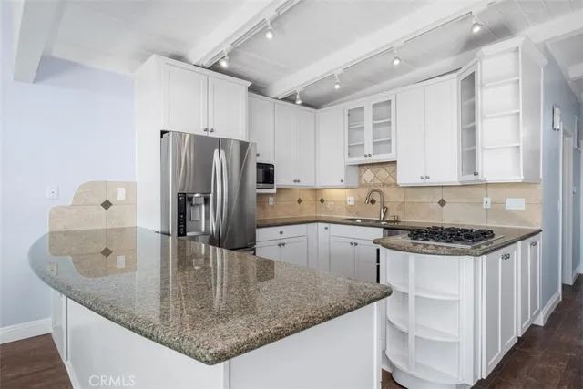 a kitchen with stainless steel appliances granite countertop a sink a stove and a refrigerator