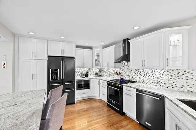 a kitchen with stainless steel appliances granite countertop a stove a refrigerator and a sink