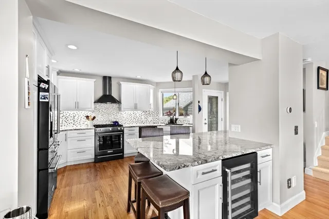 a kitchen with kitchen island granite countertop a stove cabinets and wooden floor