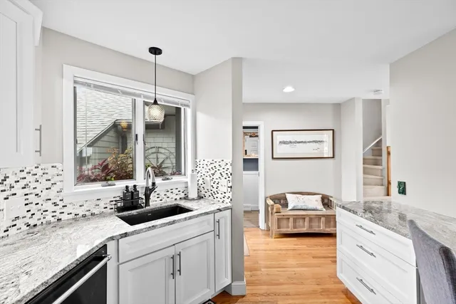 a kitchen with granite countertop a sink stove and refrigerator