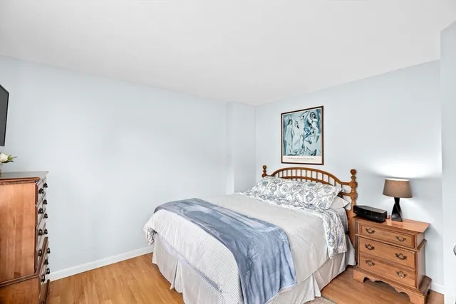 a bedroom with a bed and a lamp on the dresser