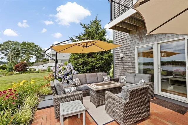 a view of a patio with couches table and chairs under an umbrella