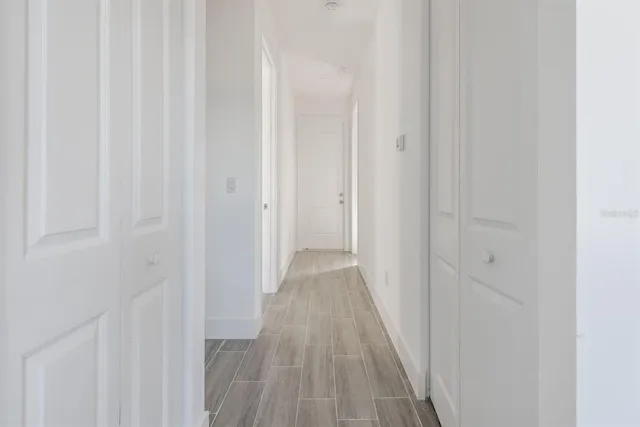 a view of a hallway with wooden floor