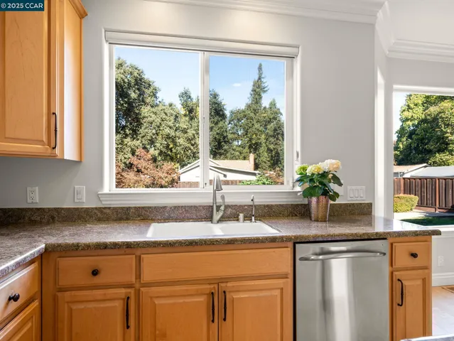 a kitchen with granite countertop white cabinets and a window