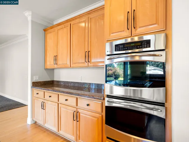 a kitchen with granite countertop white cabinets and stainless steel appliances