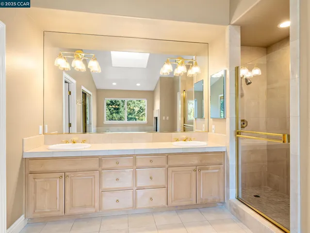 a bathroom with a granite countertop sink mirror and a shower