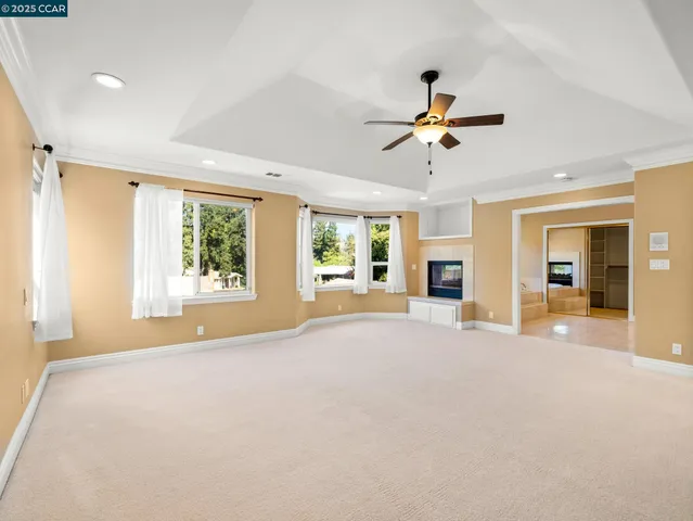 a view of a livingroom with a chandelier fan and a window