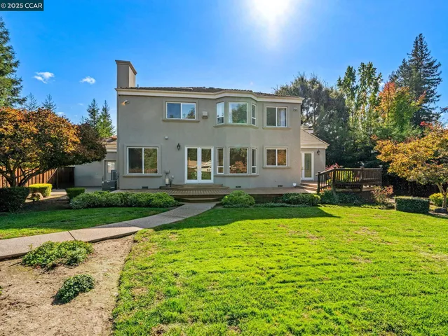 a front view of a house with garden and trees