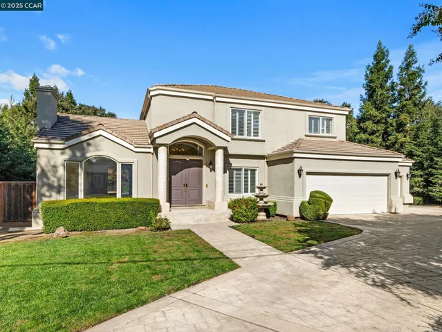 a front view of a house with a garden and plants