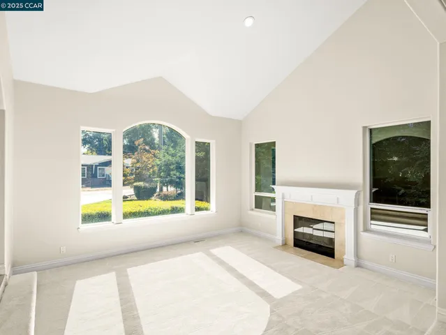 a view of an empty room with a fireplace and a window