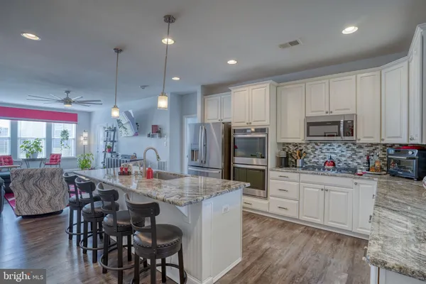 a kitchen that has a lot of cabinets a sink and a wooden floor in it