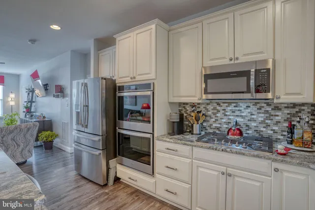 a kitchen with stainless steel appliances granite countertop a refrigerator sink and microwave