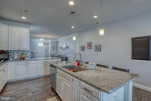 a kitchen with stainless steel appliances granite countertop a table chairs sink refrigerator and microwave