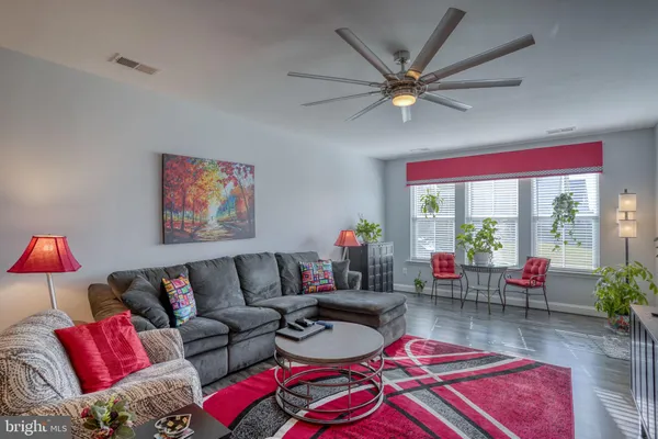 a living room with furniture kitchen view and a chandelier