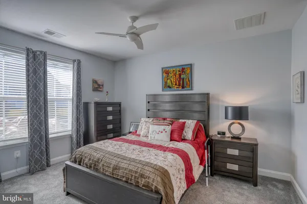 a bedroom with a bed and large windows