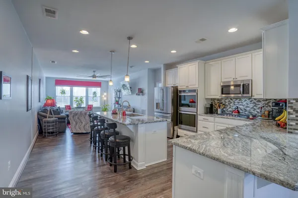 a kitchen with stainless steel appliances granite countertop a refrigerator sink and microwave
