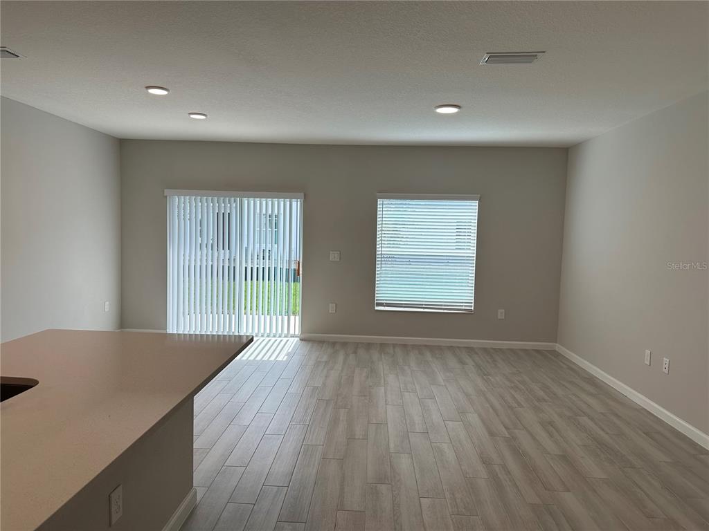 4409 Campsite Loop Orlando, FL 32824 - Photo 5 of 32 a view of an empty room with wooden floor and a window