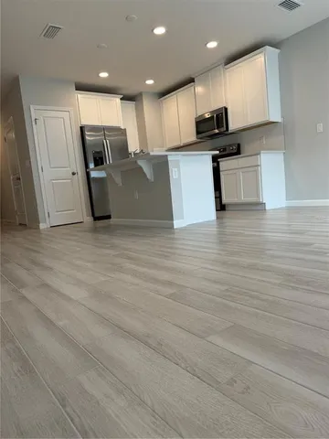 a kitchen with stainless steel appliances kitchen island granite countertop a stove a sink and a refrigerator