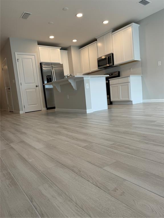 4409 Campsite Loop Orlando, FL 32824 - Photo 7 of 32 a kitchen with stainless steel appliances kitchen island granite countertop a stove a sink and a refrigerator