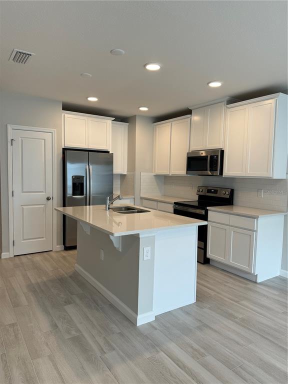 4409 Campsite Loop Orlando, FL 32824 - Photo 8 of 32 a large kitchen with a large counter top a sink stainless steel appliances and cabinets