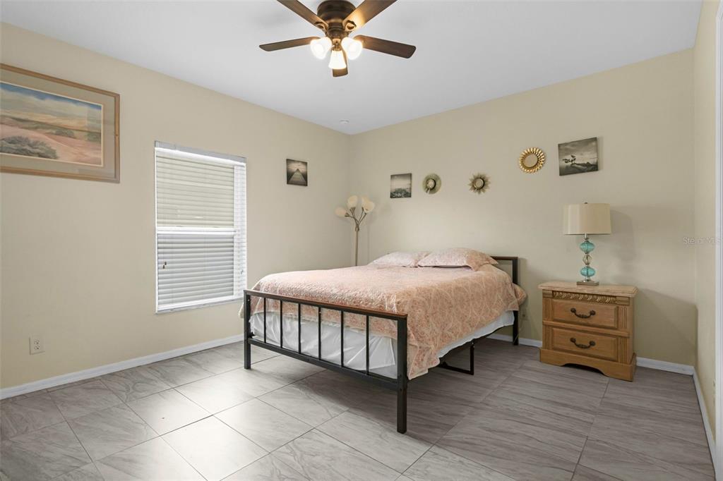 540 Vitoria Road Davenport, FL 33837 - Photo 12 of 21 a bedroom with a bed and a chandelier
