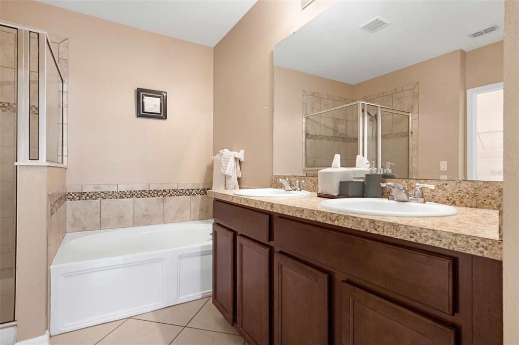540 Vitoria Road Davenport, FL 33837 - Photo 15 of 21 a bathroom with a granite countertop bathtub sink vanity and mirror