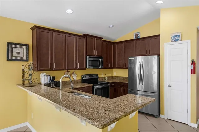 a kitchen with stainless steel appliances granite countertop a stove microwave and cabinets
