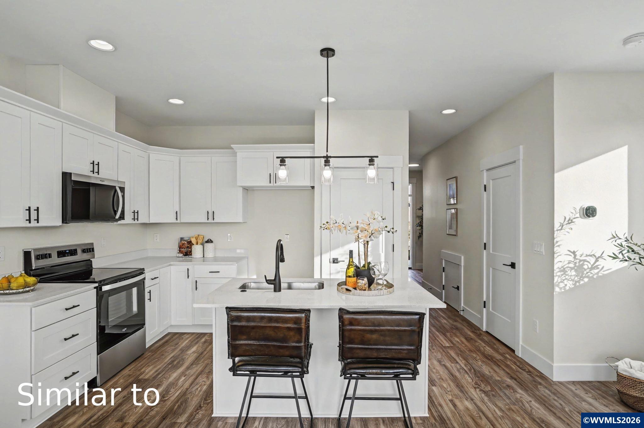 2550 Promise Way Lebanon, OR 97355 - Photo 13 of 35 a kitchen with stainless steel appliances a dining table chairs refrigerator and sink
