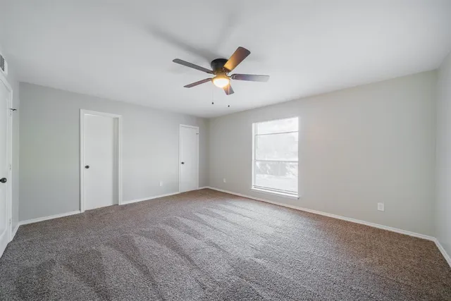 a view of a room with windows and ceiling fan