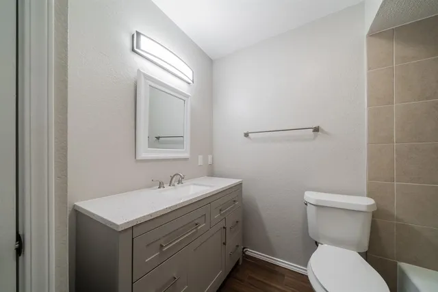 a bathroom with a toilet sink and mirror