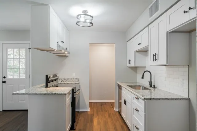 a kitchen with cabinets a sink and appliances