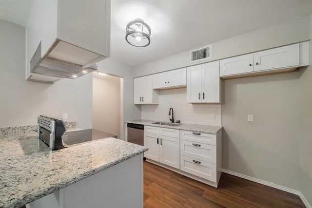 a kitchen with a sink dishwasher a stove and a refrigerator with wooden floor